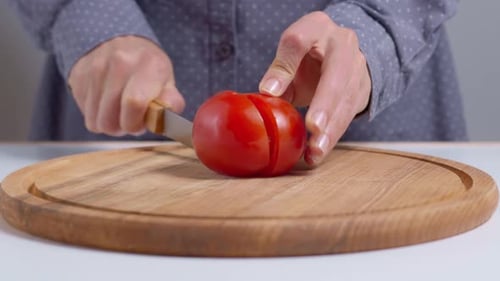 Tomato Being Cut on Wooden Cutting Board