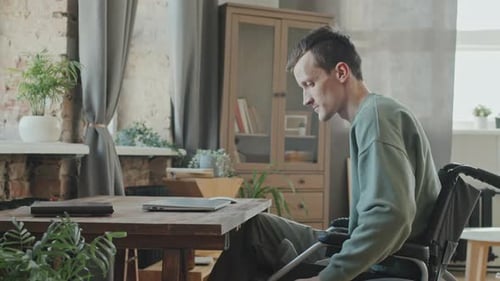 Man in Wheelchair Working at Laptop