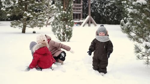 Kinder beim Bau eines Schneemanns an einem Wintertag im Hinterhof