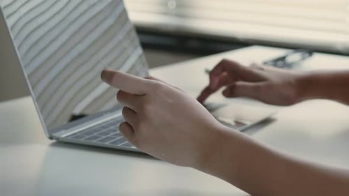 Close up hand young Asian female using a laptop shopping online and use a credit card payment.
