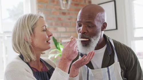 Woman Feeds Smiling Man a Bite of Food