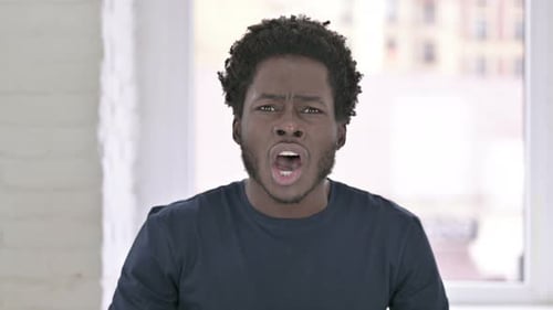 Upset young adult yelling in despair indoors