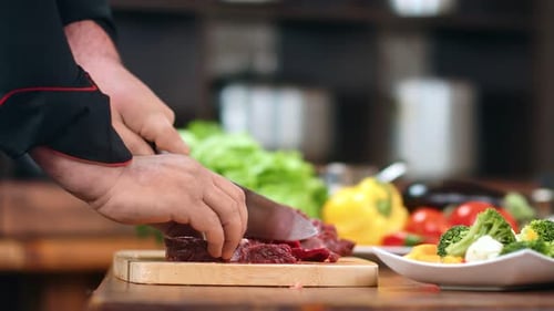 Chef Cuts Meat on Wooden Cutting Board