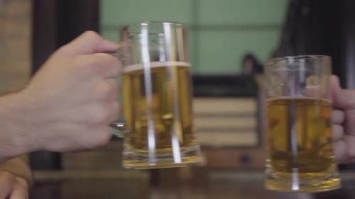 Des hommes non reconnus tintent des lunettes dans un pub