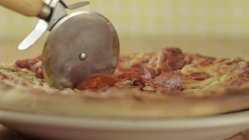 Delicious Pizza Sliced on Plate With Pizza Cutter