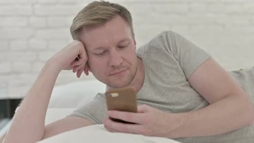 Close Up of Man Using Smart Phone While in Bed