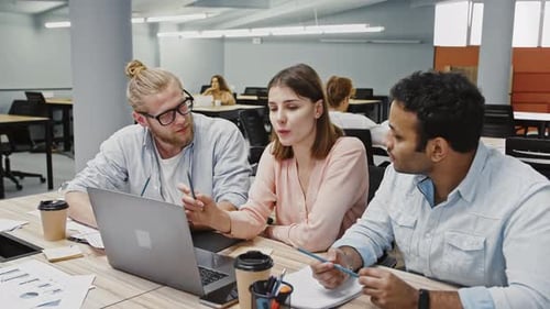 Team Collaborating on Laptop in Modern Office