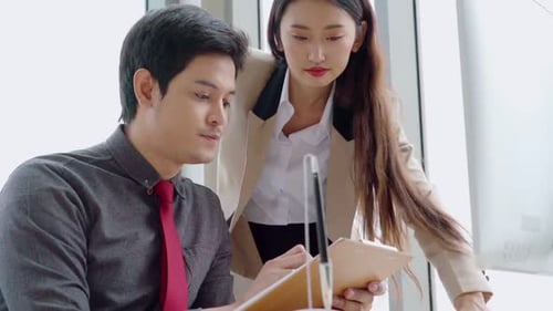 Two Business People Talk Project Strategy at Office