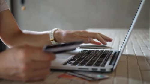 Nahaufnahme einer Frau, die online mit Laptop mit Kreditkarte einkauft