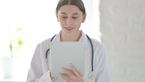 Doctor Using Tablet in Bright White Hospital Room