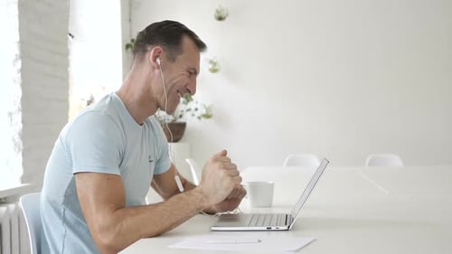Man Attends Online Meeting on Laptop