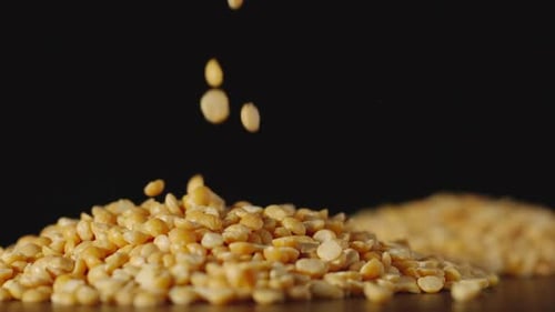 SLOW MOTION: Yellow Peas Pouring Onto A Table - Close Up