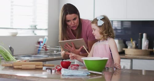 Woman and Child Baking Together in Bright Kitchen