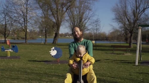 Father and son playing at seesaw in public playground, Zagreb, Croatia.