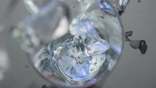 Top down view ice cubes falling and spinning into a glass in Slow motion, Close up