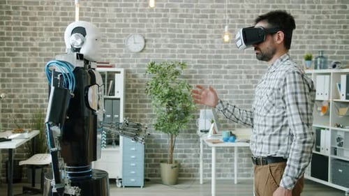 Engineer Controlling Robot Using Virtual Reality Glasses, Machine Copying Gestures