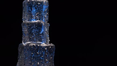 Close up ice cubes rotating on black background