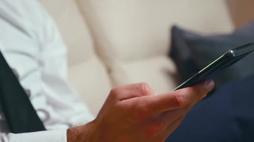 Close Up Shot of Man Hand Using a Smartphone in the Living Room