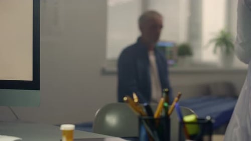 Doctor Taking Senior Man's Blood Pressure in Clinic