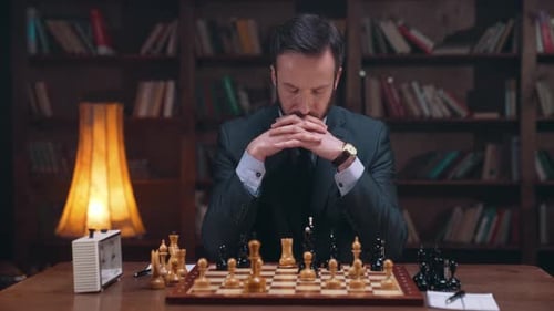 Man Thinking at Chess Board in Library Setting