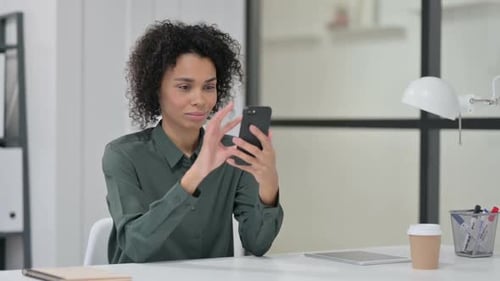 Woman Using Smartphone in Modern Office Setting