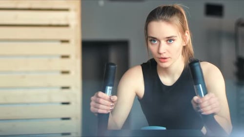 Pretty Woman in the Gym Exercising Her Legs Doing Cardio Training on Bicycle