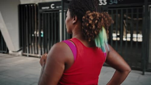 Close Up Portrait of Young Chubby African American Woman Running Alone in Urban Training Area