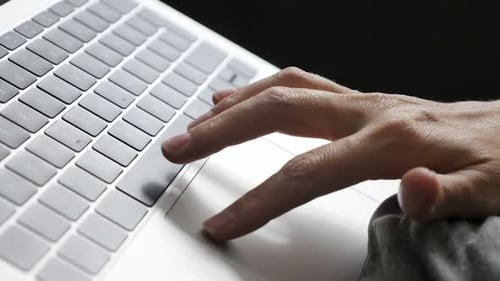 Finger touching touchpad on gray laptop 4K footage