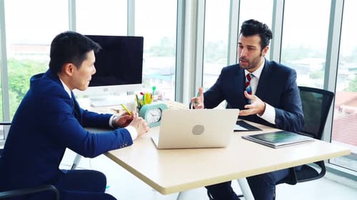 Two Business People Talk Project Strategy at Office
