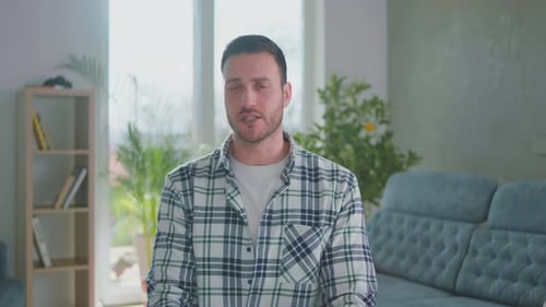 Man Talking Indoors and Waving