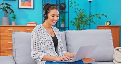 The Crazy Teenager Spends After School Time on the Couch Sitting with Laptop on Lap