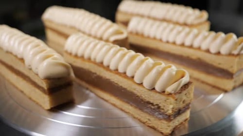 Pastries with Condensed Milk and Cream on Rotating Cake Stand in Bakehouse