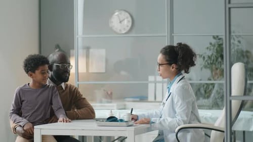 Doctor Talking To Child With Parent Present
