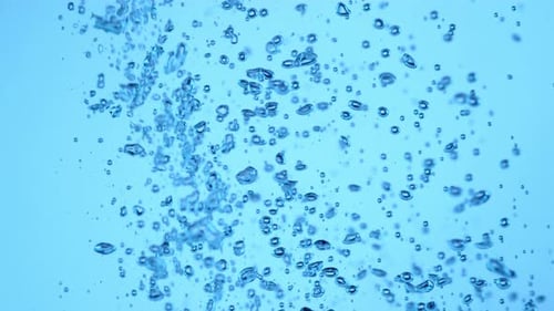 Air Bubbles Rising in Light Blue Liquid