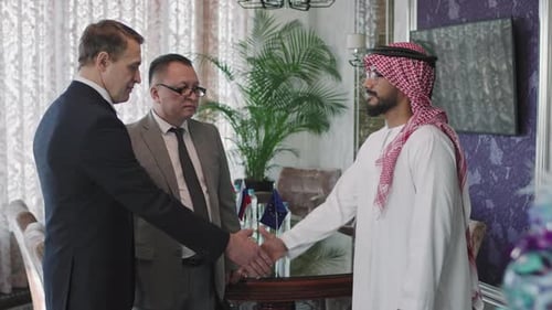 Men in Suits Shake Hands Indoors