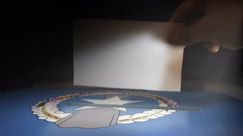 Hand Casting Vote into Ballot Box with National Flag