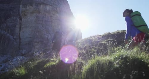 Four Friends Walking Along Hiking Trail Path with Sun Light Flare