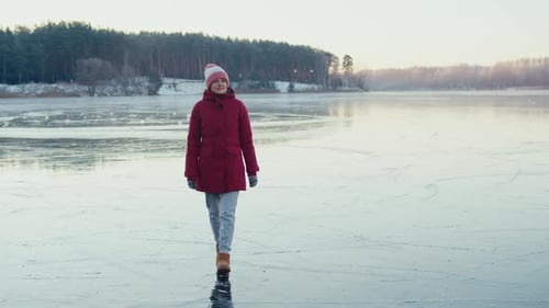 a Woman Walking on a Frozen Lake on a Frosty Day