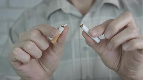 Casse une cigarette.
