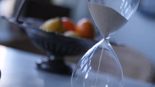 Sand Flowing Through Hourglass on Table