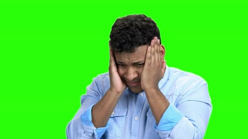 Young Man Experiencing Headache on Green Screen