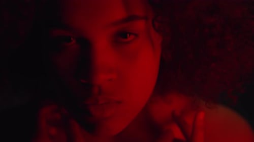 Woman's Intense Gaze in Red Lighting