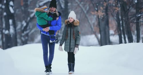 Happy Family Walks in the Winter in the Park