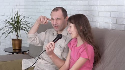Father and Daughter Singing Karaoke at Home