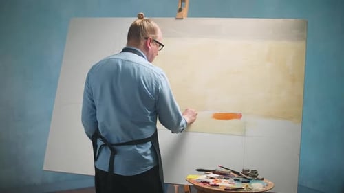 Back View of Creative Person at Work a Talented Male Artist Draws an Abstract Picture on a Large