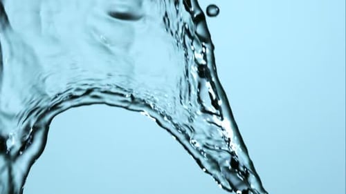 Clear Water Flowing and Twisting Against Blue Backdrop