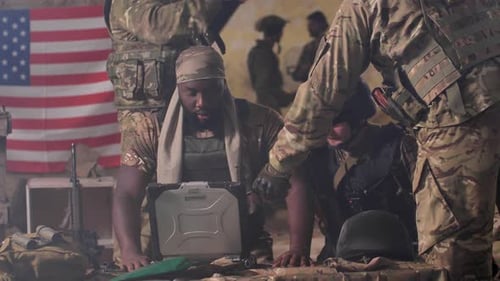 Soldiers in Camouflage Uniforms Analyzing Laptop