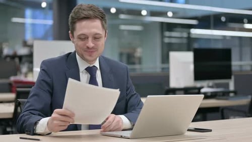 Smiling Man Working at Desk in Office