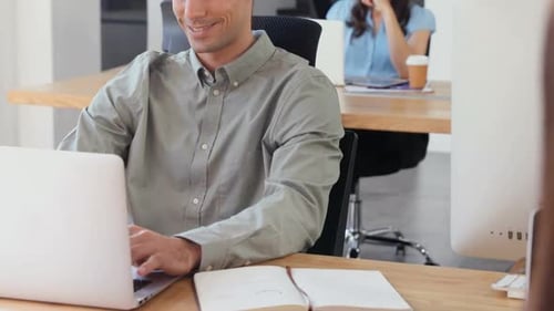 Young Adult Typing on Laptop in Modern Office