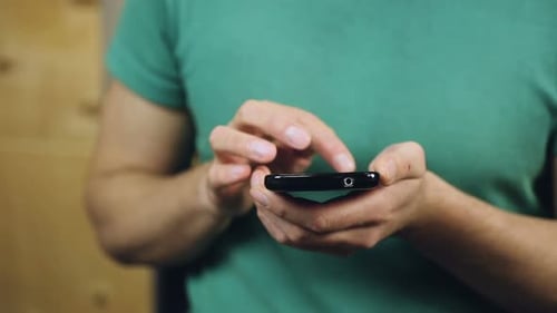 Close-Up of Male Hands Browsing Necessary Information on Smartphone, Texting